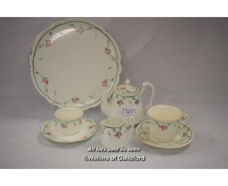 A 1920's tea set for one, comprising teapot, tray, cup and saucer plate, sugar and cream, decorated with sprigs of flowers.