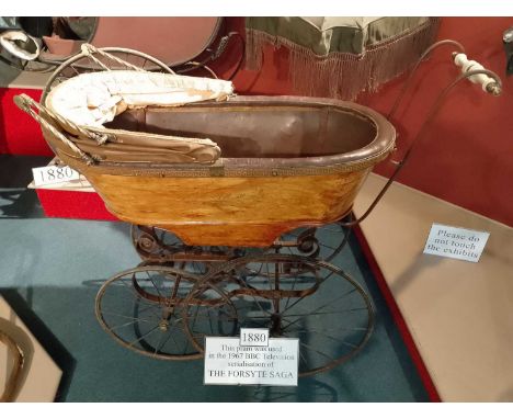 The Gallery A c.1880 pram used in the 1967 BBC series, The Forsyth Saga. Iron wheels with leather tread, gilt decoration to t