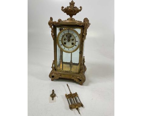 A late 19th century French brass four glass clock with two piece white enamel dial set with Roman numerals and inscribed 'Hop