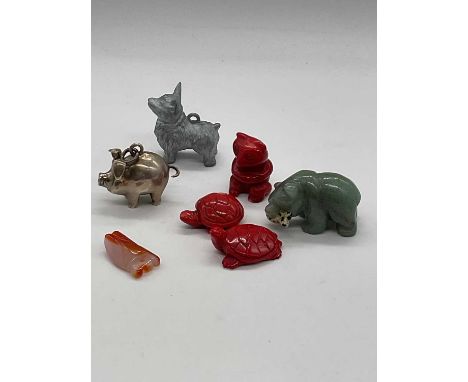 A group of small animal figures, including a coral bear, two coral carved turtles, a small bear, an agate insect, a white met