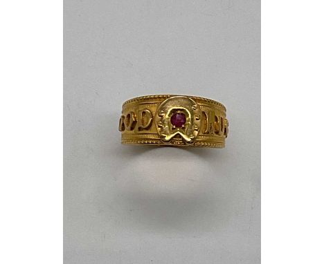 An 18ct yellow gold 'Good Luck' ring set with a ruby, size L, approx. 3.25g.Condition Report: The ring has been cut at some s