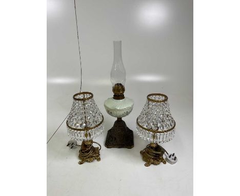 An oil lamp with cast metal base, with a floral and vaseline centre, and glass flume (lacking shade), together with a pair of