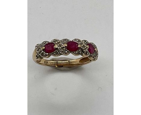 A 9ct yellow gold three stone ruby and illusion set dress ring, size N, approx. 2.45g. 