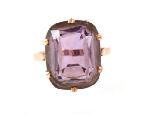 An amethyst dress ring, the rectangular cushion cut stone 18mm x 13.2mm, claw set in a rose metal mount, shank marked 9ct, ri