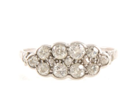 A boat shape diamond cluster ring, ten old brilliant cut diamonds graduating in size, pave set with pip claws and a milled ed