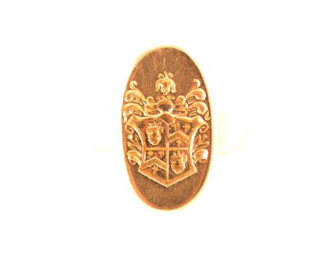 A yellow metal signet ring, the oval head 17mm x 9mm, intaglio carved with a seal depicting a crested shield, marked 18K, app
