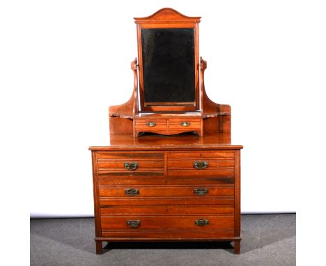 A late Victorian walnut dressing chest, mirror back with two raised trinket drawers, the base with two short and two long dra