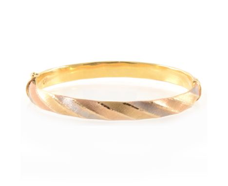 A tri-colour half hinged bangle, the 7mm wide hollow construction finely textured in three colours on the diagonal, marked 37