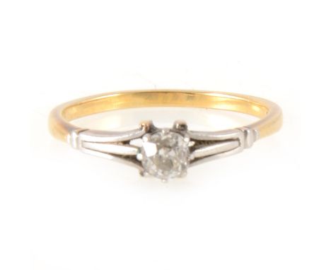 A diamond solitaire ring, the old brilliant cut stone claw set in a yellow and white metal mount with triple shoulders, shank