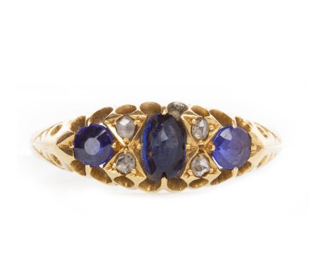 EARLY TWENTIETH CENTURY EIGHTEEN CARAT GOLD BLUE GEM AND DIAMOND RINGthe boat shaped bezel set with three graduated oval blue