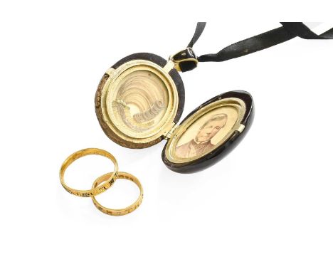 A Jet Mourning Locket, the locket carved with foliate decoration within a Greek Key border, opening to reveal hair work, susp