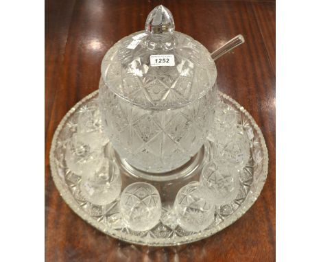 A large cut glass punch bowl on stand, with ladle and eleven cups