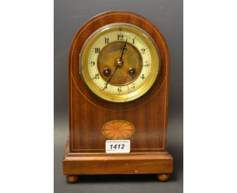 An inlaid veneered mantle clock.