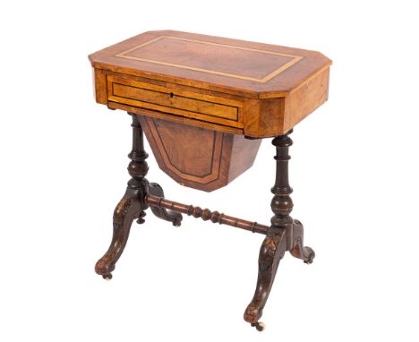 A Victorian walnut sewing table, circa 1870; the satinwood banded top with canted corners, above a drawer and a pull out fabr