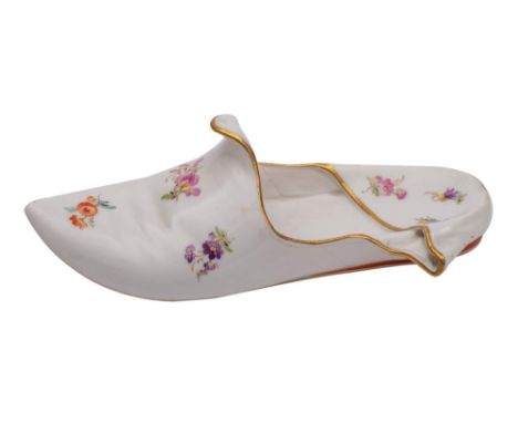 A Meissen porcelain model of a slipper painted with scattered floral sprigs and orange heel within gilt edging, crossed sword