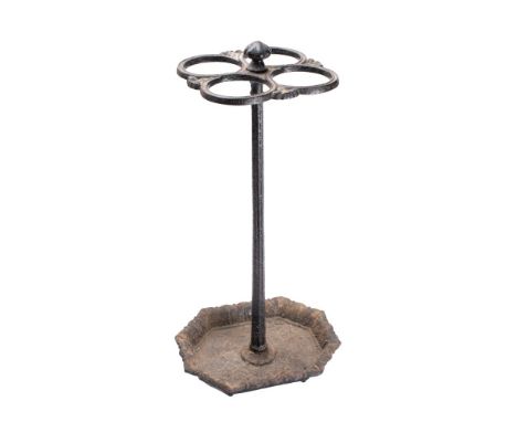 A Victorian cast iron stick stand with four circular divisions on a tapering stem raised on an octagonal dish base, 64cm high