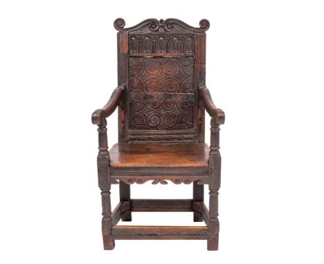 A Charles I oak wainscot elbow chair, circa 1640 and later elements; the back rest with scroll carved toprail above guilloche