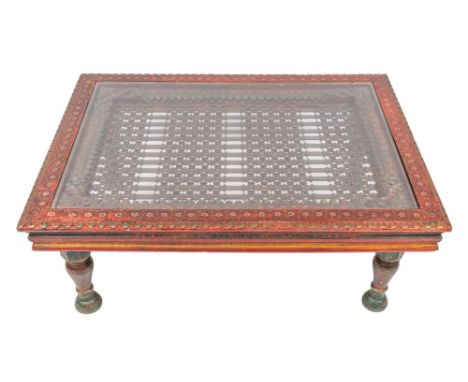An Indian carved and painted wood and wrought iron mounted low table, 20th century, incorporating earlier elements; the recta