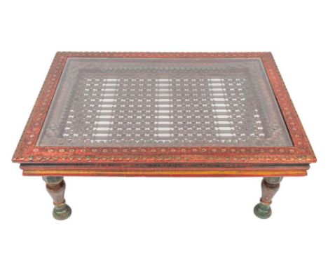 An Indian carved and painted wood and wrought iron mounted low table, 20th century, incorporating earlier elements; the recta