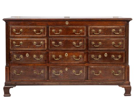A George III oak and crossbanded mule chest, circa 1775; the hinged top with moulded edges; above three registers each of fou