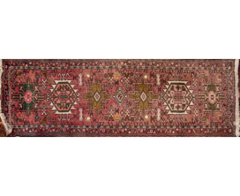 A Hamadan Runner, the rose field with a row of geometric medallions, enclosed by a geometric palmette meander border, 196cm x