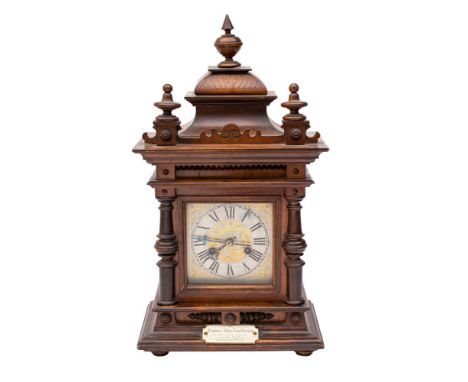 An Edwardian oak mantel clock the eight-day duration movement striking on a gong with the engraved square brass dial having b