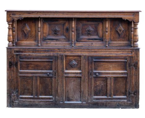 A Charles II oak court cupboard, elements 17th century and later; the canopy top with ovolo moulded edging; above twin turned