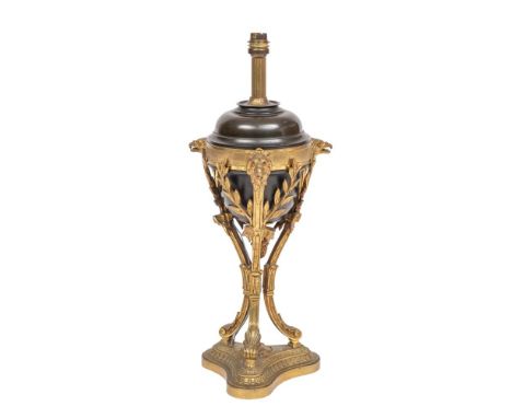 An ormolu and bronzed metal  table lamp, the urn-shaped body enclosed within three swept foliate branches,  eagle head termin