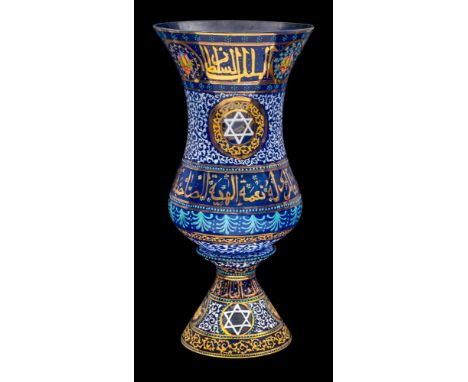 A blue glass vase or lantern, enamelled with bands of gilt Arabic script flanked by flowers and scrolling foliage and circula