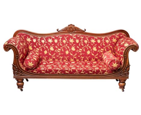 A George IV or William IV mahogany and upholstered sofa, circa 1830; the serpentine toprail of the backrest with scrolling fo