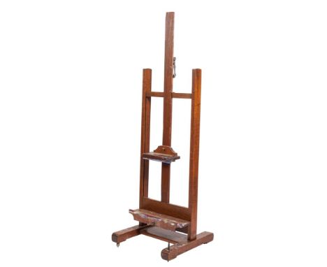 A Victorian oak studio easel, late 19th century; the 'H' frame with bevel gear mechanism; with shelf and adjustable upper sup