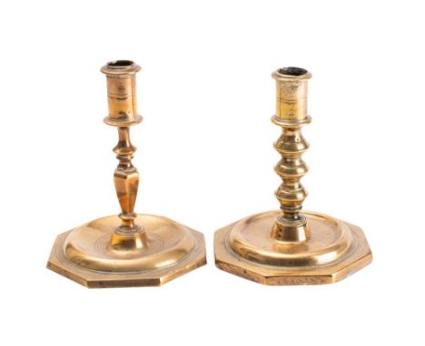 An 18th century brass candlestick with plain cylindrical sconce on a knopped and tapering stem raised on an octagonal base, 1