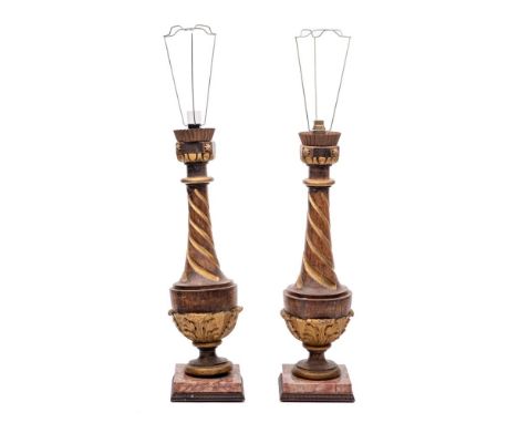 A pair of carved wood and gilt decorated table lamps of urn-shaped outline with slender spiral twist necks, with acanthus lea