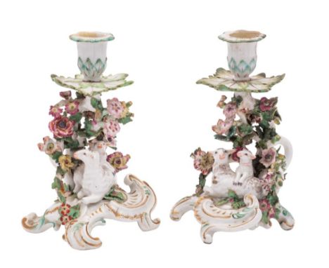 A matched pair of Chelsea ewe and lamb candlestick groups each with flowerhead sconces and foliate drip pans, flower encruste