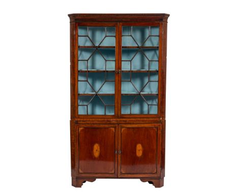 A George III mahogany and line inlaid corner display cabinet, late 18th century;  the moulded cornice above twin glazed doors