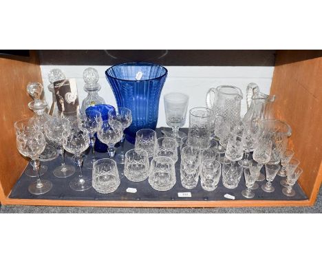 A quantity of cut lead crystal including a part suite of Waterford drinking glasses, decanters and two blue glass vases (one 