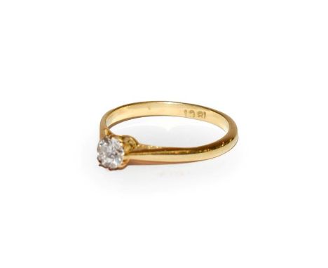 A diamond solitaire ring, the round brilliant cut diamond in a yellow claw setting, to a tapered shoulder plain polished shan