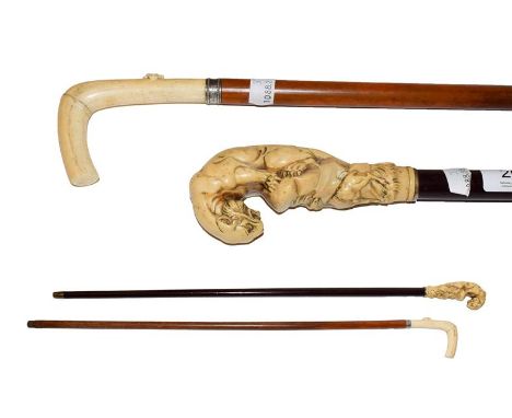 An ivory mounted walking stick, circa 1900, the handle carved as a tiger above an ibex, 89cm and a similar cane, the handle c