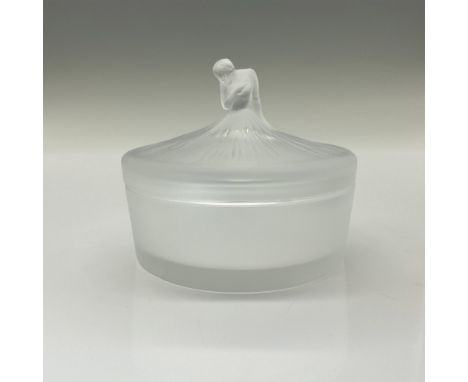 Circular powder dish features frosted lid and sides with a clear crystal bottom. Top of box is designed with inspiration from