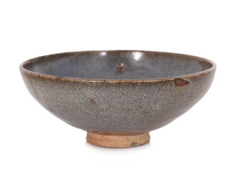 A JUN WARE BOWL
Song-Yuan dynasty, thickly potted with rounded sides rising from a short tapering foot, speckled grey-blue gl