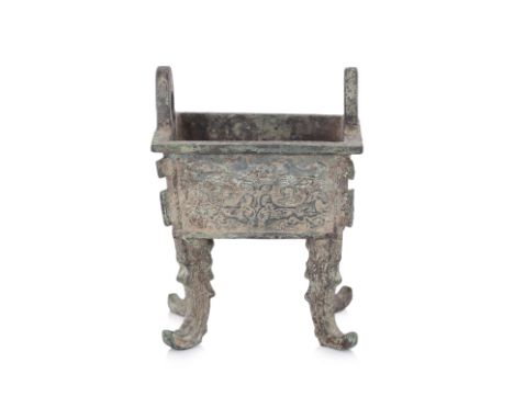 A SMALL BRONZE RITUAL FOOD VESSEL, FANG DING Rectangular cauldron with two loop lugs, decorated in stylised masks and standin