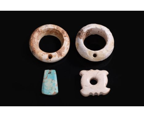 A GROUP OF FOUR NEOLITHIC LIANGZHU STONE CARVINGS A spade-form turquoise pendant, a small calcified tremolite jade disc with 