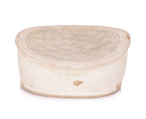 AN INCISED WHITE-GLAZED CIZHOU PILLOW
Song dynasty, oviform with sloped concave top and overhanging edges, covered in a white