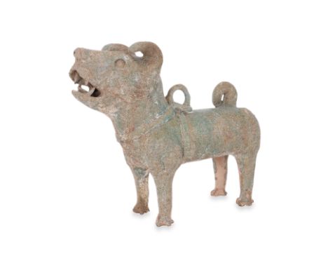 A GREEN-GLAZED POTTERY MODEL OF A DOG Han dynasty, standing facing upward with mouth open showing teeth, wearing harness coll