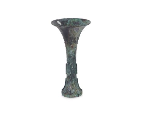A BRONZE RITUAL WINE BEAKER, GU Slender waisted cylindrical form widening at the mouth rim, four lappets of raised decoration