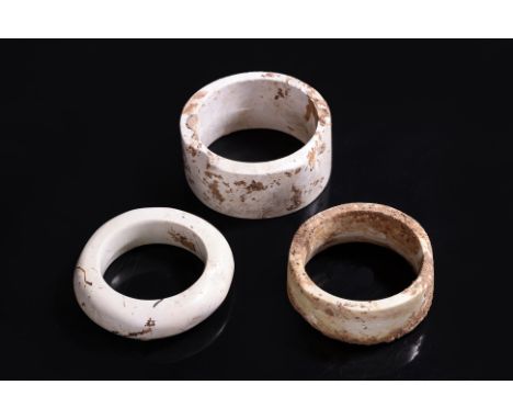 A GROUP OF THREE NEOLITHIC LIANGZHU JADE RITUAL DISCS OR BANGLES, HUAN Calcified tremolite jade with highly polished flat sur