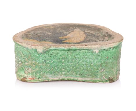 A SANCAI POTTERY INCISED PILLOW
Probably Liao-Jin dynasty, crescent form with incised scene of yellow robed scholar under moo