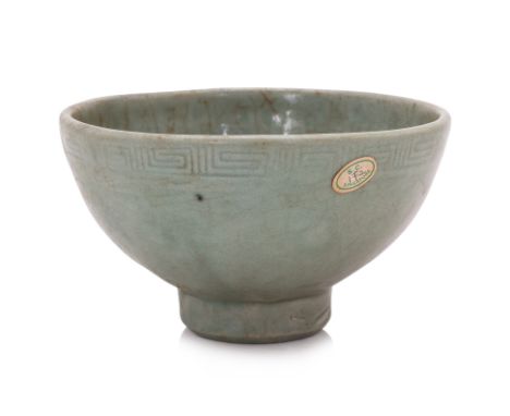 A LONGQUAN MOULDED CELADON BOWL
Ming dynasty, 15th century, the sturdily potted bowl with rounded sides raised on a thick con