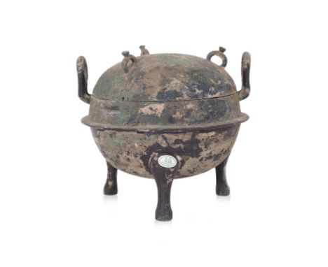 A BRONZE RITUAL FOOD VESSEL AND COVER, DING Zhou-Han dynasty, compressed globular form with two upright lugs, domed cover wit