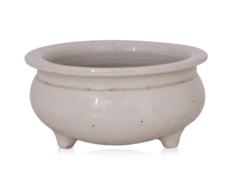 A BLANC DE CHINE TRIPOD CENSER
Circular squat-form censer with rounded sides and everted overhanging lip, the exterior covere